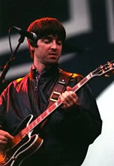 Images Dated 3rd August 1996: Noel Gallagher of Oasis playing guitar on stage during their concert at Balloch Country