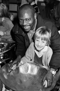 Images Dated 2nd March 1988: North Star steel drummer Kelvin Benjamin helps Sarah Stead play the soprano drum during