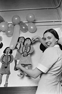 A nurse decorates a childrens hospital in Birmingham. 20th December 1975