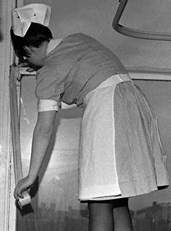 A nurse tapes up a draughty window in an Infirmary ward. 10th April 1970 A nurse tapes up a draughty window in an Infirmary ward. 10th April 1970