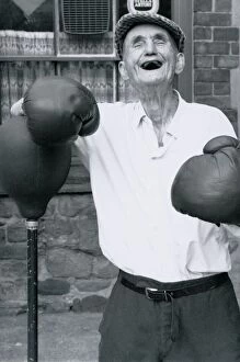Old age pensioner Jackie McGuire aged 92 Standing beside punch ball wearing boxing