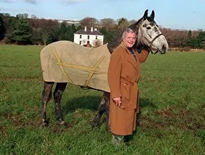 Images Dated 27th February 1996: Oliver Reed actor wearing brown long coat standing in field with his horse Bobby at home