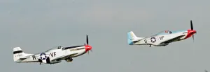 A pair of P51 North American Mustangs flying in formation at the Wroughton Airshow in A pair of P51 North American Mustangs flying in formation at the Wroughton Airshow in