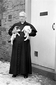 The parish priest seen here gathering up his pet cats.. February 1970 70-1627-005