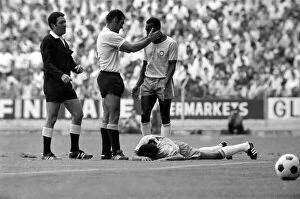 Images Dated 10th July 1970: Pele is calmed down by a Uruguain player whilst a felled Jairzinho lies on the ground
