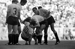 Images Dated 10th July 1970: Pele is helped to his feet by a Uruguain player. Brazil v. Uruguay: World Cup Semi-Final