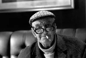 Pensioner: Elderly man filling his pools coupon whilst enjoying a cigarette Pensioner: Elderly man filling his pools coupon whilst enjoying a cigarette