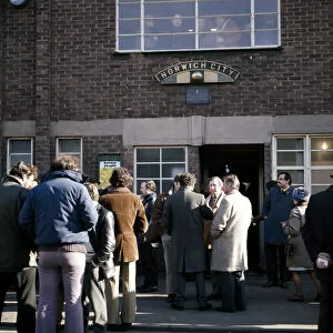 People gathered outside the entrance to Norwich City football club at Carrow Road