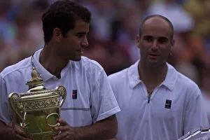 Pete Sampras with trophy watched by Andre Agassi after Pete had won the Mens Final Pete Sampras with trophy watched by Andre Agassi after Pete had won the Mens Final