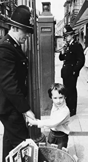 Police officers with a little boy who is lost in the city centre of Cambridge Police officers with a little boy who is lost in the city centre of Cambridge
