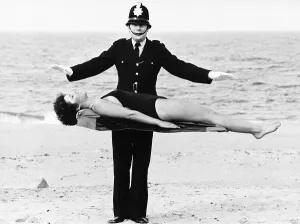 Policeman Bob Averill from Wallsend Tyne and Wear levitates Julia Wall on the sands of Policeman Bob Averill from Wallsend Tyne and Wear levitates Julia Wall on the sands of