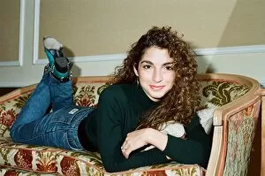 Images Dated 31st October 1988: Pop singer Gloria Estefan poses lying down on a sofa in her hotel room on a visit to