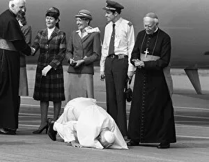 Images Dated 2nd June 1982: Pope John Paul II kneels down and kisses the ground at Cardiff airport on his visit to