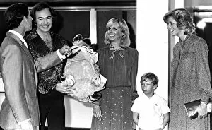 Images Dated 5th July 1984: Prince Charles and Diana share a joke with singer Neil Diamond over a Garfield cuddly toy