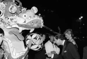 Images Dated 25th February 1988: Prince Charles and Princess Diana observing a Chinese dragon as they attend the premier