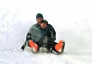 Images Dated 5th January 1997: Prince Charles on a sledge with Prince Harry while on holiday in Klosters