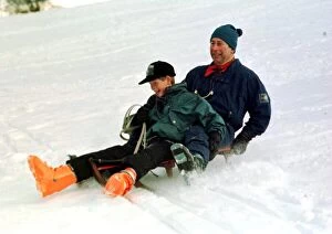Images Dated 5th January 1997: Prince Charles on a sledge with Prince Harry while on holiday in Klosters Switzerland