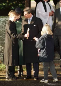 Prince Charles watches as Prince William receives a present from a young local girl at Prince Charles watches as Prince William receives a present from a young local girl at