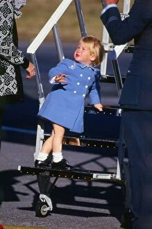 Prince Harry July 1987 wearing a blue coat standing on the steps of a plane