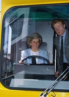 Princess Diana, Princess of Wales at the wheel of a bus watched by John Fowler during a