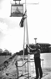 Publican Fred Howe lowers the Union Jack outside his hostel