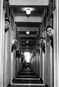 RAF recruits pop their heads out from the doorways of their new room-a-man quarters at RAF recruits pop their heads out from the doorways of their new room-a-man quarters at