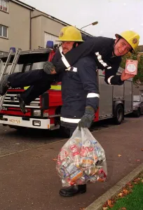 Rangers football player Ally McCoist as a fireman with a smoke alarm in one hand getting Rangers football player Ally McCoist as a fireman with a smoke alarm in one hand getting