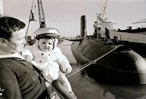 One of the ratings of the new submarine HMS Conqueror shows off his new ship to his son