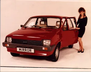 RED METRO MODEL STANDING NEXT TO CAR COMPETITION PRIZE MINI METRO RED METRO MODEL STANDING NEXT TO CAR COMPETITION PRIZE MINI METRO
