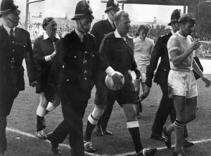 Referee David Smith gets a police escort as he leaves the Maine-road pitch following a Referee David Smith gets a police escort as he leaves the Maine-road pitch following a