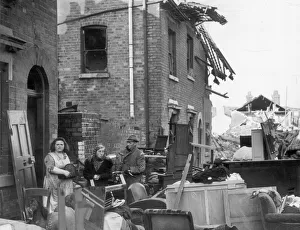 Residents of a Coventry street stand outside their ruined homes after the city was Residents of a Coventry street stand outside their ruined homes after the city was