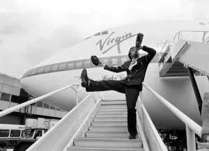 Images Dated 21st June 1984: Richard Branson drinking from a bottle of champagne as he celebrates Virgin Atlantic