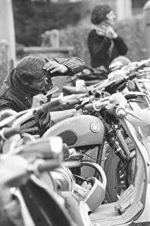 00573 Gallery: Rocker combs his hair using the mirror of a mods scooter on Clacton sea front