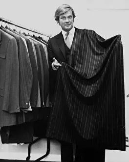 Roger Moore actor holding a length of suiting cloth October 1970 he is a director of Roger Moore actor holding a length of suiting cloth October 1970 he is a director of