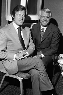 Images Dated 16th June 1971: Roger Moore and Cary Grant sample one of their perfumes during their visit to their