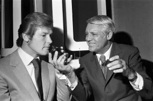 Images Dated 16th June 1971: Roger Moore and Cary Grant sample one of their perfumes during their visit to their