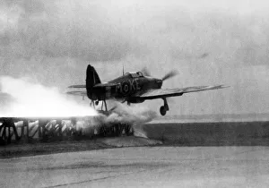 A Royal Air Force Hawker Hurricane is catapaulted down a launching ramp on the bow of a A Royal Air Force Hawker Hurricane is catapaulted down a launching ramp on the bow of a