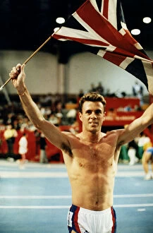 Runner Tom McKean holding up Union Jack in the Kelvin Hall after winning race athletics