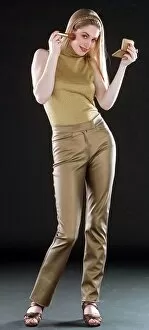 Images Dated 17th December 1996: Ruth Kemmer model wearing gold trousers and top applying blusher to her face with a brush