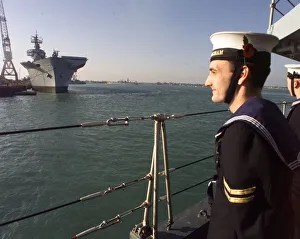 A sailor from HMS Birmingham stands to attention as the ship passes HMS Ark Royal in A sailor from HMS Birmingham stands to attention as the ship passes HMS Ark Royal in