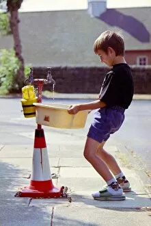 Images Dated 15th August 1995: Sandpipes in Bradford - a boy fills a bucket full of water from an outside tap