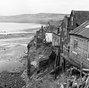 Shored up houses on the cliffs at Robin Hood's Bay, North Yorkshire. 3rd March 1970