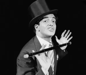 Singer Frankie Vaughan on stage performing in top hat and holding a cane Singer Frankie Vaughan on stage performing in top hat and holding a cane