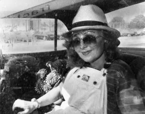 Images Dated 1st September 1979: Singer Lulu in the back of a car wearing a trilby hat, sunglasses and dungarees