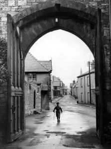 A small boy walks through the archway at the entrance of Ruthin Castle Denbighshire A small boy walks through the archway at the entrance of Ruthin Castle Denbighshire