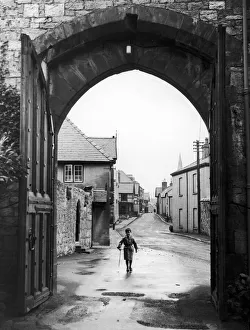 A small boy walks through the archway at the entrance of Ruthin Castle Denbighshire A small boy walks through the archway at the entrance of Ruthin Castle Denbighshire
