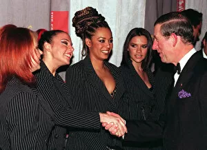 Images Dated 15th December 1997: Spice Girls Geri Halliwell Mel B and Victoria Adams look on as Mel C shakes hands
