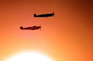 A Spitfire and ME109 (bottom) fly over the war memorial, with a low autumnal sun behind A Spitfire and ME109 (bottom) fly over the war memorial, with a low autumnal sun behind