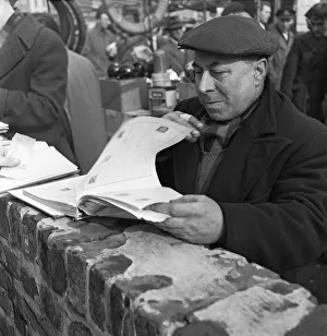 A stamp collector looking to add to his collection at the flea market in Club Row A stamp collector looking to add to his collection at the flea market in Club Row