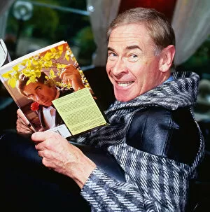 Stanley Baxter holding book with picture of himself on it September 1986